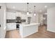 A modern, all-white kitchen features stainless steel appliances, grey backsplash and a large island at 27 Kensington St, Kingston, GA 30145
