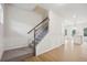 Carpeted staircase with decorative wainscoting leads to the upper level at 27 Kensington St, Kingston, GA 30145