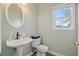 Well-lit half-bathroom featuring a decorative sink, toilet, and window providing natural light at 45 Cherrystone Walk, Suwanee, GA 30024