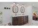 Elegant bathroom featuring a dual sink vanity with sleek mirrors and decorative lighting at 45 Cherrystone Walk, Suwanee, GA 30024