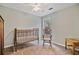 Cozy bedroom with a crib, rocking chair, and ample natural light from a large window at 45 Cherrystone Walk, Suwanee, GA 30024