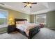 Well-lit main bedroom featuring a large bed, tray ceiling, and windows with peaceful views at 45 Cherrystone Walk, Suwanee, GA 30024