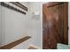 Rustic mudroom features a bench, coat hooks, decorative accents, and a solid stained wood door at 45 Cherrystone Walk, Suwanee, GA 30024