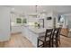 Well-lit kitchen boasts an island with bar stools, stainless steel appliances, white cabinetry, and granite countertops at 45 Cherrystone Walk, Suwanee, GA 30024