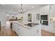 Open-concept kitchen with large island featuring cooktop, white cabinets, stainless appliances, and views to dining area at 45 Cherrystone Walk, Suwanee, GA 30024