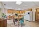 Eat-in kitchen features wood cabinets, white appliances, and a charming dining area with colorful chairs at 45 Cherrystone Walk, Suwanee, GA 30024