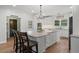 Bright and modern kitchen with white cabinets, granite countertops, an island with seating, and stainless appliances at 45 Cherrystone Walk, Suwanee, GA 30024
