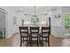 A view of the open kitchen with white cabinets, stainless steel appliances, and a large kitchen island with bar stool seating at 45 Cherrystone Walk, Suwanee, GA 30024