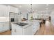A spacious kitchen with a large island, stainless steel refrigerator, and views of the living and dining areas at 45 Cherrystone Walk, Suwanee, GA 30024