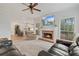 Open-concept living room with a brick fireplace, comfortable seating, and view to the kitchen at 45 Cherrystone Walk, Suwanee, GA 30024