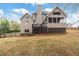 Backyard featuring the rear home exterior, a deck, stairs, a well-kept lawn, and landscaping at 6935 York Pl, Cumming, GA 30040
