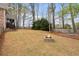 Expansive backyard features a fire pit, trampoline, and mature trees providing a scenic outdoor space at 6935 York Pl, Cumming, GA 30040