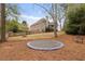 Lush backyard with an in-ground trampoline and mature trees, offering privacy and plenty of space at 6935 York Pl, Cumming, GA 30040