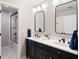 Modern bathroom with double vanity, sleek black fixtures, mirrors, and tiled shower at 6935 York Pl, Cumming, GA 30040