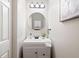 Well-lit powder room with a modern mirror and neutral color palette at 6935 York Pl, Cumming, GA 30040