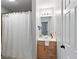 Full bathroom features a shower with a curtain, a wooden vanity with countertop, and ample lighting at 6935 York Pl, Cumming, GA 30040