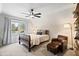 Cozy bedroom featuring a ceiling fan, chair, bookshelves, and a view to the front yard at 6935 York Pl, Cumming, GA 30040