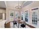Sunlit dining area with wood floors, chandelier, and views of the backyard and screened porch at 6935 York Pl, Cumming, GA 30040