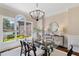 Elegant dining room with a glass table, modern chandelier, and bright natural light at 6935 York Pl, Cumming, GA 30040
