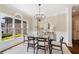 Bright dining room featuring a modern glass table, stylish chandelier, and large windows at 6935 York Pl, Cumming, GA 30040