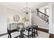 Light-filled dining area with glass table, elegant chandelier, and staircase views at 6935 York Pl, Cumming, GA 30040