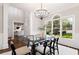 Spacious dining room with glass table, stylish chandelier, and views to a study at 6935 York Pl, Cumming, GA 30040