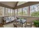 Cozy screened porch with porch swing, outdoor seating, and views of the wooded backyard at 6935 York Pl, Cumming, GA 30040