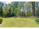 Expansive backyard featuring a well-manicured lawn, mature trees, and inviting seating at 931 Fairfield Dr, Marietta, GA 30068