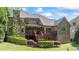 Beautiful backyard featuring stone chimney, covered porch, wood deck, and tiered landscaping at 931 Fairfield Dr, Marietta, GA 30068