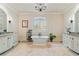 Luxurious bathroom with dual vanities, travertine flooring, a standalone tub, and a decorative chandelier at 931 Fairfield Dr, Marietta, GA 30068