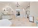 Large bathroom with travertine floors, glass shower, custom vanities, and open doorway to another room at 931 Fairfield Dr, Marietta, GA 30068