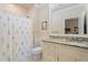 Clean bathroom with a granite countertop, shower with floral curtain, and tile floors at 931 Fairfield Dr, Marietta, GA 30068