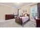 Cozy bedroom with carpeted floors, a wooden bed, and bright windows at 931 Fairfield Dr, Marietta, GA 30068