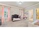 Charming bedroom with a crib, plantation shutters and elegant pink floral decorations and drapes at 931 Fairfield Dr, Marietta, GA 30068