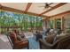 Inviting covered deck with wooded views features a ceiling fan, brick columns, and comfortable wicker seating at 931 Fairfield Dr, Marietta, GA 30068