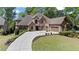 Stately brick and stone home with a circular driveway and beautifully landscaped front yard at 931 Fairfield Dr, Marietta, GA 30068