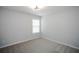 A cozy bedroom featuring neutral carpeting, fresh paint and a window offering ample natural light at 1905 Granville Dr, Lawrenceville, GA 30043