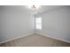 A cozy bedroom featuring neutral carpeting, fresh paint and a window offering ample natural light at 1905 Granville Dr, Lawrenceville, GA 30043