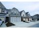 Exterior shot of townhomes with two-car garages and varied colors and stone details at 1905 Granville Dr, Lawrenceville, GA 30043