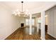 Open-concept living area and dining room showcasing hardwood floors, a fireplace, and a modern chandelier at 1905 Granville Dr, Lawrenceville, GA 30043