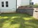 A backyard with a well-maintained lawn and a retaining wall for landscaping at 30 Riverrock Trl, Dallas, GA 30157
