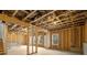 Unfinished basement with exposed beams, framed walls, and natural light from multiple windows at 30 Riverrock Trl, Dallas, GA 30157
