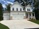 Beautiful two-story home featuring white siding, brick accents, and a spacious three-car garage at 30 Riverrock Trl, Dallas, GA 30157