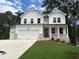 Charming two-story home with white siding, brick accents, a well-manicured lawn and a three car garage at 30 Riverrock Trl, Dallas, GA 30157