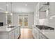 Open kitchen design boasts white cabinets, a spacious island, and a view to a deck at 30 Riverrock Trl, Dallas, GA 30157