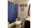 Bathroom with blue shower curtain and decorative nautical art at 4691 Bo Hendrick Dr, Austell, GA 30106