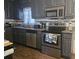 Sleek kitchen boasts gray cabinets, modern stainless steel appliances, and granite countertops at 4691 Bo Hendrick Dr, Austell, GA 30106