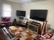 Comfortable living room features a leather sofa, a plaid rug, and a large flat screen television at 4691 Bo Hendrick Dr, Austell, GA 30106