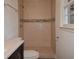 Tiled shower with glass doors and decorative accent border, offering a modern touch at 4691 Bo Hendrick Dr, Austell, GA 30106