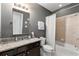 Well-lit bathroom with a granite countertop, dark cabinets, and a shower-tub combo for relaxation at 4852 Merriman Se Walk # 23, Atlanta, GA 30339